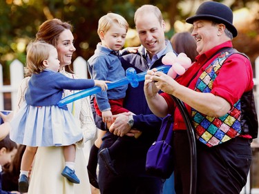 Britain's Prince William (2nd R), Catherine, Duchess of Cambridge (2nd L), Prince George and Princess Charlotte (L) watch as a man inflates balloons at a children's party at Government House in Victoria, Thursday, September 29, 2016.