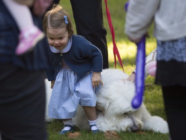 Princess Charlotte sits on a dog during a children's party in Victoria, B.C. Thursday, Sept 29, 2016.