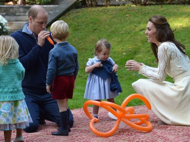 Prince William blows up a balloon as he and his wife Kate, the Duchess of Cambridge, take part in a tea party with their children, Prince George and Princess Charlotte, at Government House in Victoria, Thursday, Sept. 29, 2016.