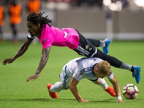 Central FC's Jason Marcano (left) trips over Vancouver Whitecaps' Bret Levis.