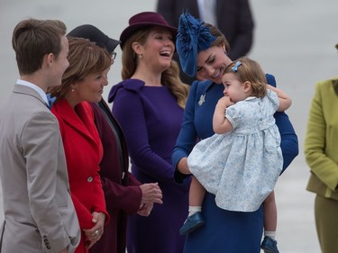 The Duchess of Cambridge, centre, holds her daughter Princess Charlotte as she speaks with British Columbia Premier Christy Clark, second left, while Prime Minister Justin Trudeau's wife Sophie Gregoire Trudeau, back, share a laugh, upon the family's arrival in Victoria, B.C., on Saturday, September 24, 2016.