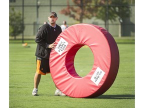 B.C. Lions running backs coach Adam Blasetti, working at the team's practice facility in Surrey Tuesday, has an affinity for big, red doughnuts ... and tackling rings. Arlen Redekop/PNG