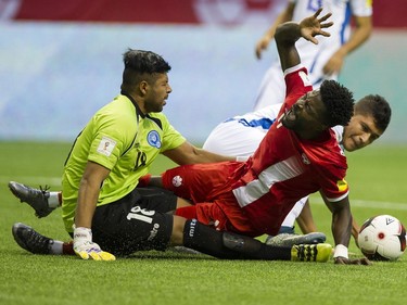 Tosaint Ricketts collides with El Salvador goalkeeper Oscar Arroyo after a tackle from Roberto Dominguez.