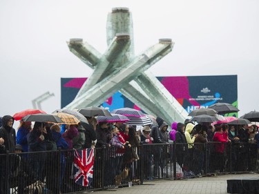 A large crowd huddles under umbrellas during a passing shower while waiting for the arrival of Prince William, Duke of Cambridge and Catherine, Duchess of Cambridge at Jack Poole Plaza in Vancouver, BC, September, 25, 2016.