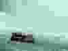 The tiny boat gets up close to the waterfall.