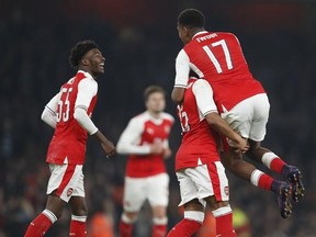 Arsenal&#039;s Alex Oxlade-Chamberlain, second right, catches Arsenal&#039;s Alex Iwobi as he celebrates scoring a goal during the English League Cup soccer match between Arsenal and Reading at Emirates stadium in London, Tuesday, Oct. 25, 2016. (AP Photo/Kirsty Wigglesworth)