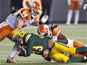 B.C. Lions Adam Bighill (44) and Solomon Elimimian (56) tackle Eskimos Chris Getzlaf (89) during first-half CFL action in Edmonton on Sept. 23.