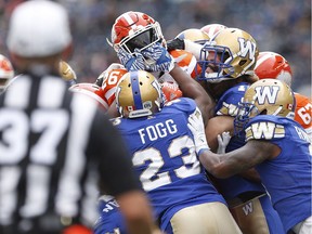 B.C. Lions' Anthony Allen (26) runs against Winnipeg Blue Bombers' Kevin Fogg (23) during the first half of CFL action in Winnipeg Saturday.