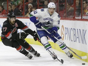 Carolina Hurricanes Justin Faulk (27) and Vancouver Canucks Bo Horvat (53) chase the puck during an NHL game in Raleigh, N.C., on Jan. 15.