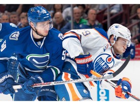 Vancouver Canucks' Brendan Gaunce, left, checks Edmonton Oilers' Leon Draisaitl, of Germany, during the first period of an NHL hockey game in Vancouver, B.C., on Friday, October 28, 2016.