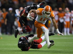 B.C. Lions' Bryan Burnham, front, gets away from Ottawa Redblacks' Mitchell White and Jeff Richards, bottom, during the first half of Saturday's game at B.C. Place.