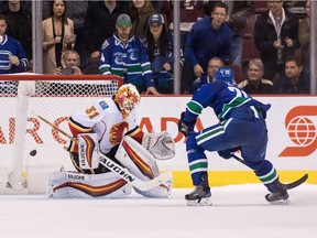 Brandon Sutter #20 of the Vancouver Canucks scores the game winning goal against goaltender Chad Johnson #31 of Calgary Flames during a shootout of their NHL game at Rogers Arena on October 15, 2016.