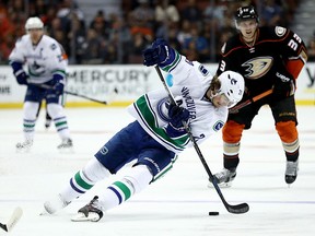 Loui Eriksson of the Canucks skates past the puck as Jakob Silfverberg of the Ducks looks on.