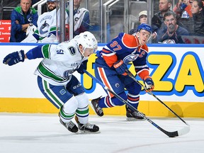 Connor McDavid of the Oilers battles against Troy Stecher on October 8, 2016 at Rogers Place in Edmonton.