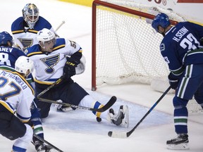 St. Louis Blues left wing David Perron (57) tries to stop Vancouver Canucks centre Henrik Sedin (33) from scoring the game winning goal in overtime during NHL action in Vancouver, B.C. Tuesday, Oct. 18, 2016.