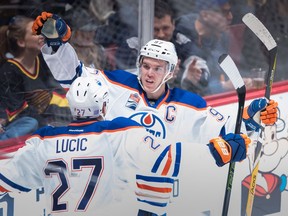 Edmonton Oilers' Connor McDavid, back, and Milan Lucic celebrate McDavid's goal against the Vancouver Canucks during the second period of an NHL hockey game in Vancouver, B.C., on Friday October 28, 2016.