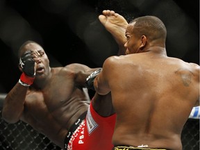 Anthony Johnson kicks Daniel Cormier during their light heavyweight title mixed martial arts bout at UFC 187 on Saturday, May 23, 2015, in Las Vegas.