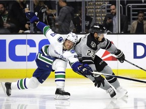 Los Angeles Kings' Dustin Brown, right, is defended by Vancouver Canucks' Philip Larsen during the second period of an October game, in Los Angeles. The two teams play again tonight at Rogers Arena.