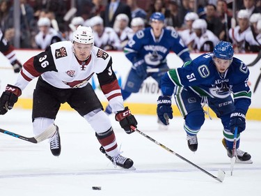 Arizona Coyotes' Christian Fischer, left, and Vancouver Canucks' Troy Stecher skate after the puck during the first period of a pre-season NHL hockey game in Vancouver, B.C., on Monday October 3, 2016.