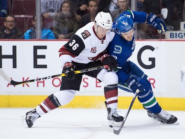 Arizona Coyotes' Christian Fischer, left, tries to move the puck past Vancouver Canucks' Nikita Tryamkin, of Russia, during the first period of a pre-season NHL hockey game in Vancouver, B.C., on Monday October 3, 2016.