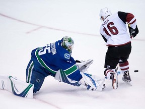 Vancouver Canucks' goalie Jacob Markstrom, left, of Sweden, comes out of his crease to poke-check the puck away from Arizona Coyotes' Max Domi on a breakaway during the second period of a pre-season NHL hockey game in Vancouver, B.C., on Monday October 3, 2016.