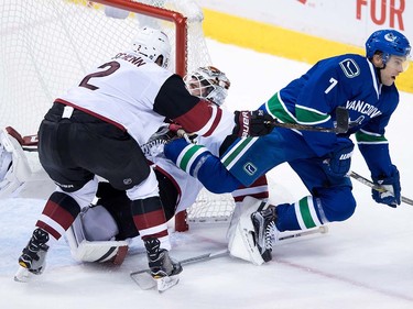 Vancouver Canucks' Tuomo Ruutu, right, of Finland, is checked into Arizona Coyotes' goalie Louis Domingue, back, by Luke Schenn during the second period of a pre-season NHL hockey game in Vancouver, B.C., on Monday October 3, 2016.