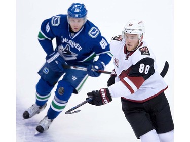 Arizona Coyotes' Jamie McGinn, right, and Vancouver Canucks' Markus Granlund, of Finland, watch the puck during the first period of a pre-season NHL hockey game in Vancouver, B.C., on Monday October 3, 2016.