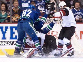Vancouver Canucks' Tuomo Ruutu, back centre, of Finland, falls over Arizona Coyotes' goalie Louis Domingue as he covers up the puck while teammate Brad Richardson, right, and Canucks' Joseph Labate watch during the first period of a pre-season NHL hockey game in Vancouver, B.C., on Monday October 3, 2016.