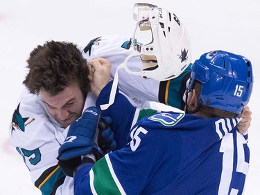 San Jose Sharks' Alex Gallant, left, loses his helmet while fighting Vancouver Canucks' Derek Dorsett during the second period of a pre-season NHL hockey game in Vancouver, B.C., on Sunday October 2, 2016.