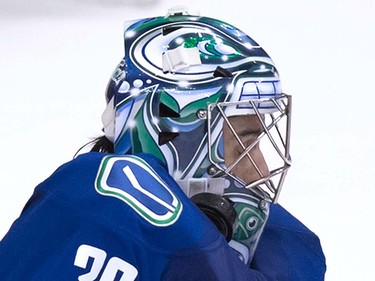 Vancouver Canucks' goalie Ryan Miller is struck by the puck during the overtime period of a pre-season NHL hockey game against the San Jose Sharks in Vancouver, B.C., on Sunday October 2, 2016.