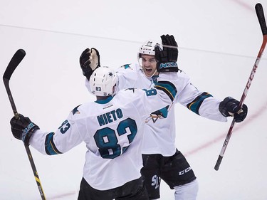 San Jose Sharks' Matt Nieto, front, and Dylan DeMelo celebrate Nieto's goal against the Vancouver Canucks during the overtime period of a pre-season NHL hockey game in Vancouver, B.C., on Sunday October 2, 2016.