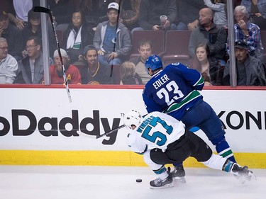 San Jose Sharks' Tommy Wingels, front, loses his stick after colliding with Vancouver Canucks' Alexander Edler, of Sweden, during the third period of a pre-season NHL hockey game in Vancouver, B.C., on Sunday October 2, 2016.