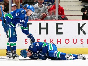Sven Baertschi checks on teammate Bo Horvat after he took a crosscheck from St. Louis's Alex Steen Tuesday night.