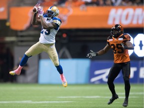 Winnipeg Blue Bombers' Kevin Fogg, left, intercepts a pass intended for B.C. Lions' Shawn Gore during the second half of a CFL football game in Vancouver, B.C., on Friday October 14, 2016.