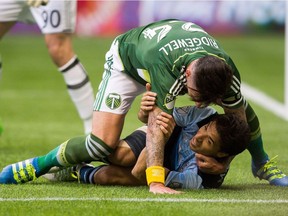 Vancouver Whitecaps Nicolas Mezquida (11) is taken to the ground by Portland Timbers Liam Ridgewell during a game at B.C. Place earlier this year.