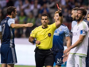 Referee Ricardo Salazar gives a red card to Seattle Sounders' Brad Evans while playing against the Vancouver Whitecaps during the second half MLS soccer action in Vancouver, B.C., on Sunday October 2, 2016.