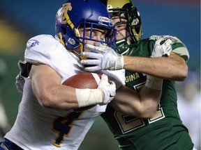 UBC's Ben Cummings, left, and University of Regina Rams Joey Dwyer get tangled up at Mosaic Stadium in Regina.