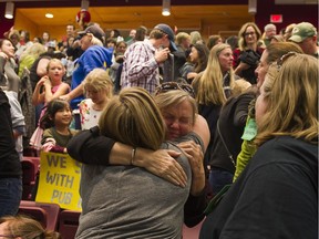 Parents hug in celebration after the Richmond school board voted Tuesday against any school closures.