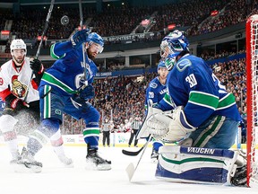 Derick Brassard of the Ottawa Senators and Erik Gudbranson of the Vancouver Canucks follow the puck in front of Ryan Miller #30 of the Canucks during their NHL game at Rogers Arena October 25, 2016 in Vancouver, British Columbia, Canada.