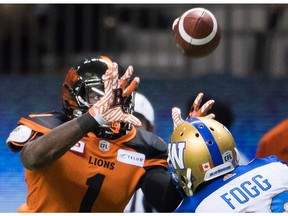 B.C. Lions' Terrell Sinkfield Jr., left, makes a reception as Winnipeg Blue Bombers' Kevin Fogg watches during the first half of Fridays game at B.C. Place.