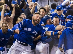 The Blue Jays celebrate their walk-off win to eliminate the Texas Rangers during the 10th inning to win the American League Division Series in Toronto on Sunday. — THE CANADIAN PRESS