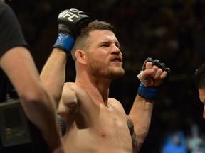 Michael Bisping raises his arms to the crowd as he enters the cage for his middleweight championship bout at UFC 199 at The Forum on June 4, 2016 in Inglewood, California.