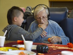 Five-year-old Tony Han Jr. lends a helping hand to 100-year-old Alice Clark at Youville Residence care facility in Vancouver in October.