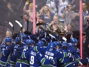 Vancouver Canucks centre Henrik Sedin (33) celebrates his game winning goal over the St. Louis Blues with his teammates following overtime during NHL action in Vancouver, B.C. Tuesday, Oct. 18, 2016.