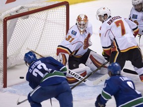 Vancouver Canucks left wing Daniel Sedin puts a shot past Calgary Flames goalie Chad Johnson as Calgary Flames defenceman TJ Brodie looks on during the third period Saturday night. The goal came after a magnificent two-minute shift conducted entirely in the Flames' zone.