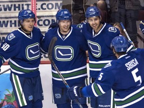 Brandon Sutter (second from right) and Markus Granlund (far left) celebrate linemate Jannik Hansen’s goal while defenceman Luca Sbisa joins the party during the Vancouver Canucks’ 2-1 win over the visiting Buffalo Sabres on Thursday.