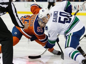 Mark Letestu #55 of the Edmonton Oilers faces off against Brendan Gaunce #50 of the Vancouver Canucks on April 6, 2016 at Rexall Place in Edmonton, Alberta, Canada.