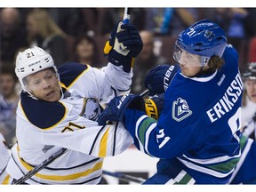 The Sabres' Kyle Okposo pushes the Canucks' Loui Eriksson.
