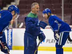 Vancouver Canucks head coach Willie Desjardins has his players’ full attention during a team practice at Rogers Arena on Thursday. The Canucks open their 2016-17 season at home Saturday against the Calgary Flames.