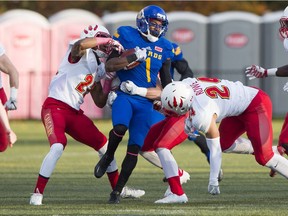 UBC Thunderbirds Trivel Pinto tries to break the tackles of the University of Calgary Dinos during CIS Canada West football action at UBC on Saturday.